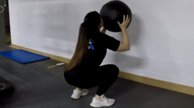 Medizinball-Kniebeuge mit Wandwurf